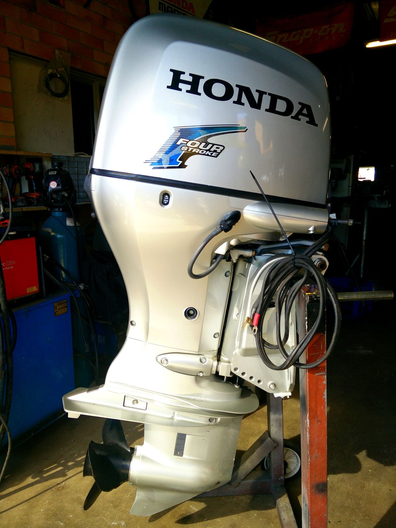 Honda four stroke outboard on a stand in the workshop