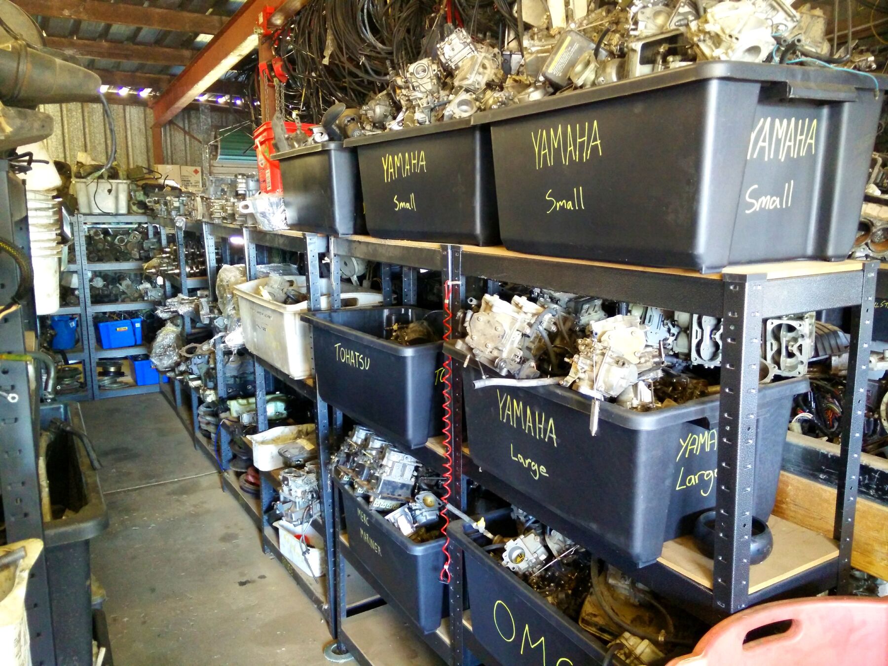 Rows of labelled parts tubs for Yamaha, Tohatsu, Merc Mariner and OMC motors